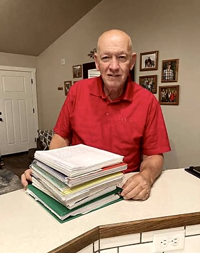 Greg Roesberry with his stack of handwritten manuscripts